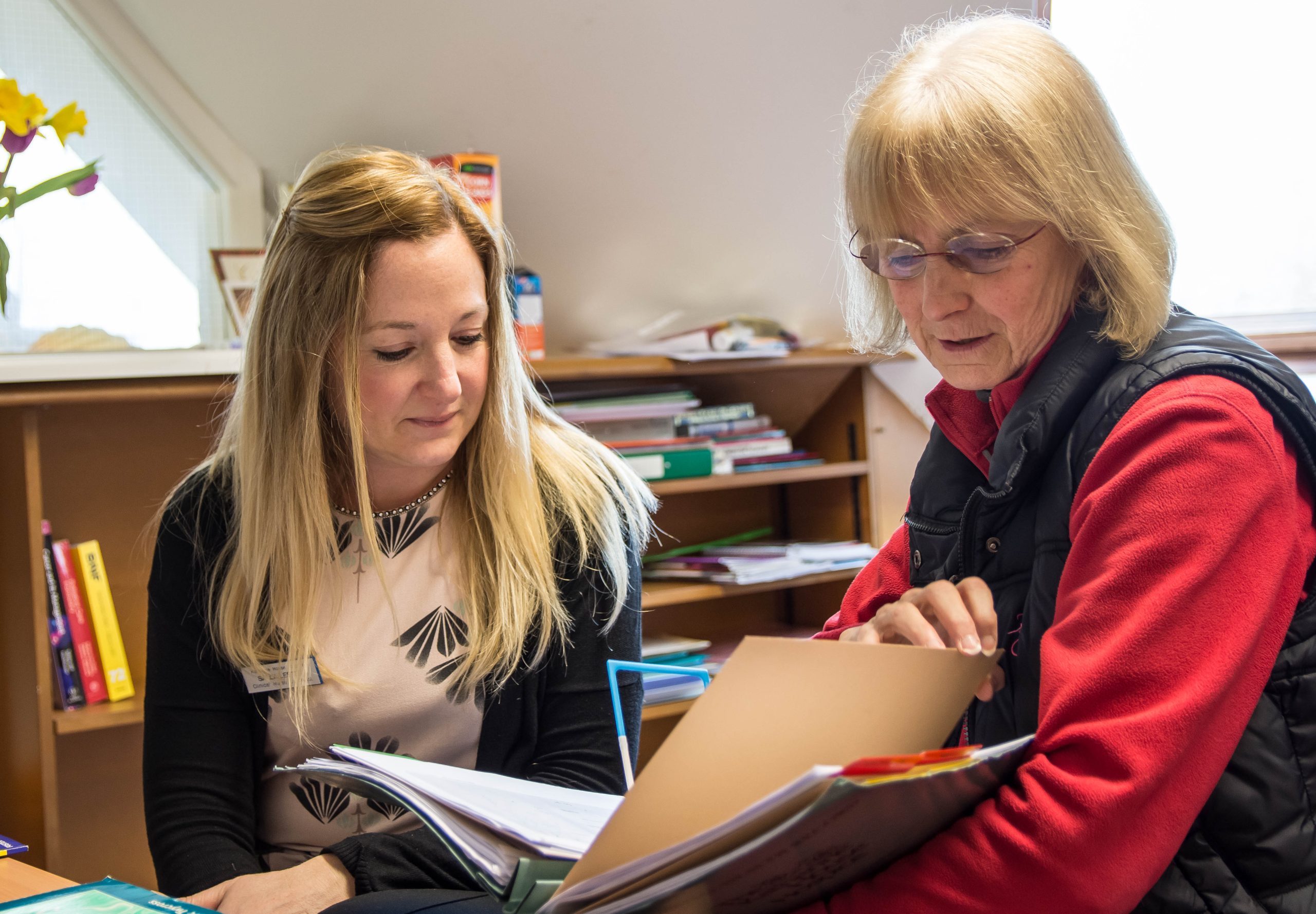 Two support workers viewing a file
